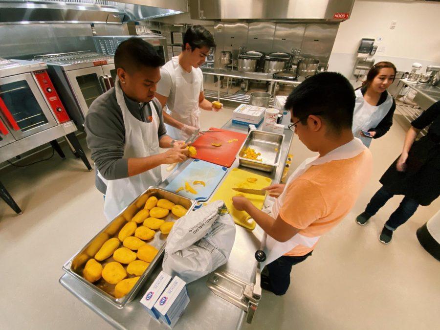 Beaver's Digest and Cambodian Student Association volunteers peel and slice ripe mangos together in the Global Community Kitchen at OSU. Photo taken by Morgan Grindy. 