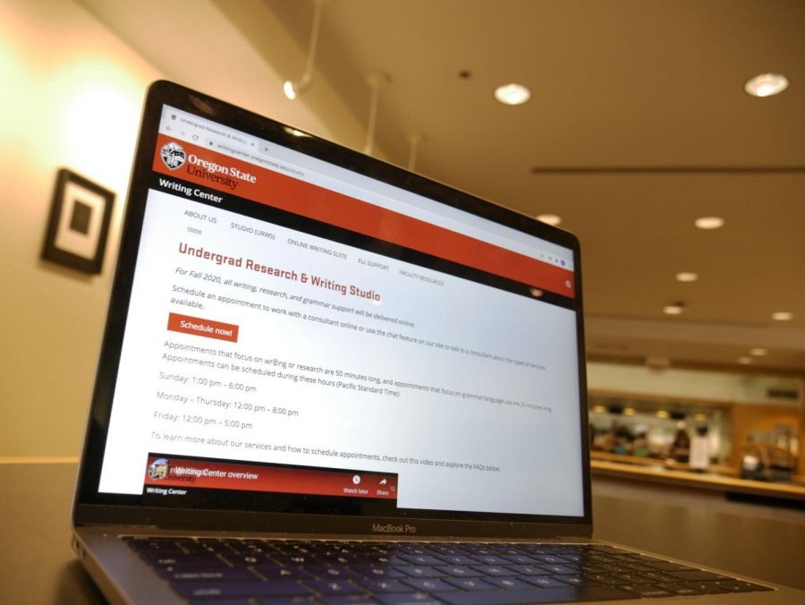 A laptop in the library with the Undergrad Research & Writing Studio homepage on it. Although the Writing Studio is only available virtually, students can still reserve spaces in the library for when they plan to use it.
