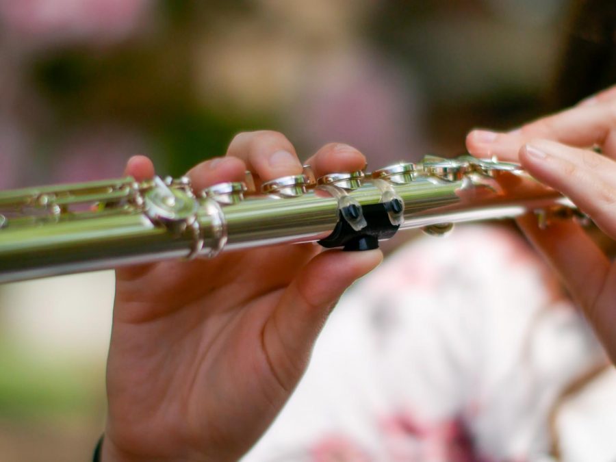 Flute+player+and+recent+Oregon+State+Alumni+Stephanie+Hanson+playing+the+flute+through+her+Oregon+State+Band+mask+in+front+of+Bexell+Hall.+To+reduce+the+likeliness+of+music+students+spreading+COVID%2C+Oregon+State+music+students+use+special+masks+that+allow+them+to+play+and+filter+the+air+they+breathe.