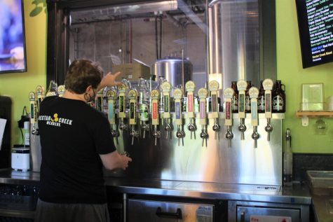 Tap room associate Wyette Hennessey, fills up a glass of handmade cider on Saturday at 2 Towns Ciderhouse.