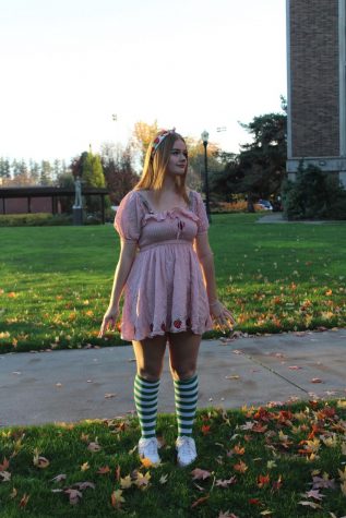 An OSU student dresses Strawberry Shortcake stands in a pile of fallen leaves on campus.