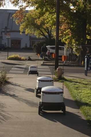 3 delivery robots crossing road