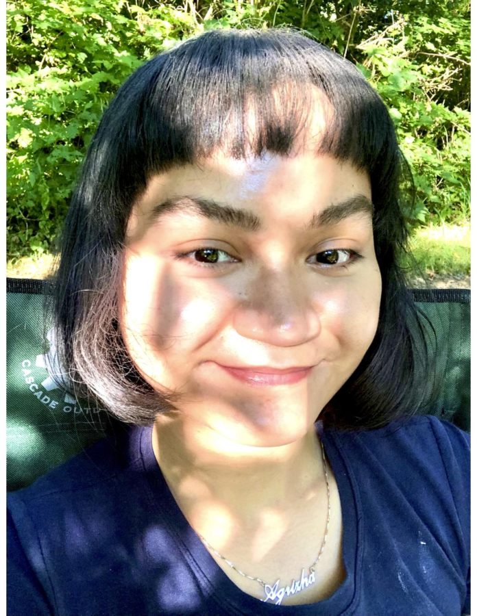 A selfie of Agrizha Puspita Sari outside with shadows from a tree cast across her face.