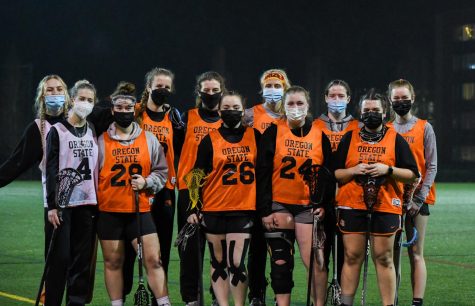 The entire women's lacrosse team poses together on the intramural field.