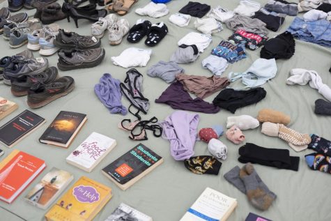 A table covered with books, shoes, underwear, socks, bras and even slippers.