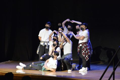 A group of students pose together on stage.