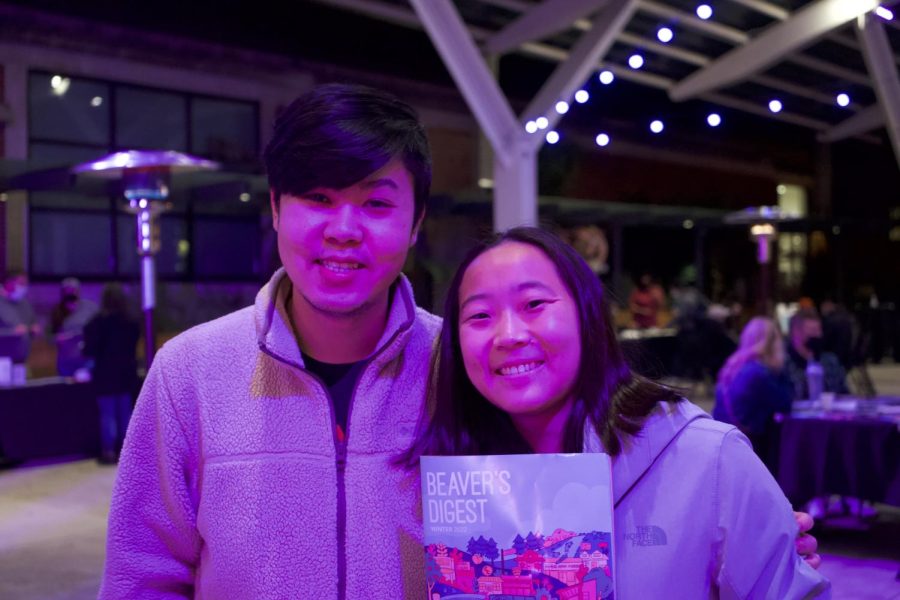 Nam Pham (left) smiles with Jessica Li (right) while holding up the magazine.