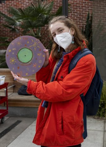 Amanda Appel holds up her record art. Her art features stars, the sun, and the words "you are my sunshine."