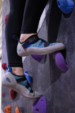 Oregon State University student Brooklynn Rawski climbs for her first time at The Valley Rock Gym. This photo shows a close-up shot of her climbing shoes as she scales the wall.