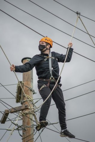 A student makes their way through the challenge course in the air.