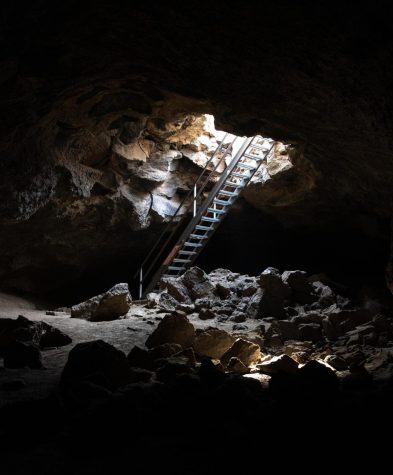 Inside the cave, light shines through the hole in the ceiling where stairs lead out of Boyd Caves.