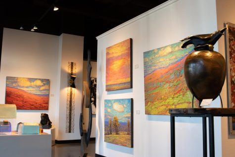 The art gallery displays landscape paintings, a vase, statues and sculptures.