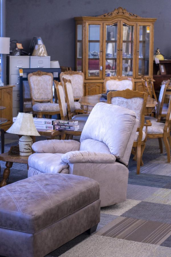 Furniture pieces, such as a recliner, dining chairs, an ottoman, a side table and a lamp are displayed in a furniture store.