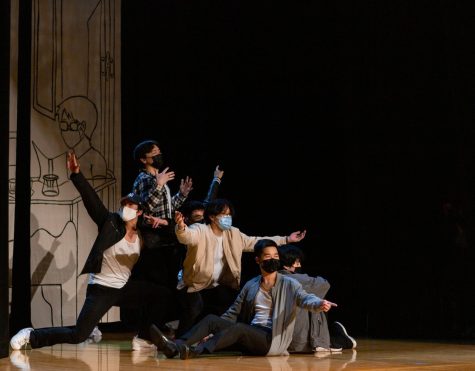 A group of performers pose on stage together at the end of their dance.