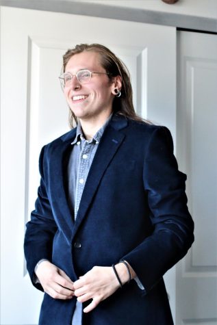 student Christopher Batemen putting on a suit jacket