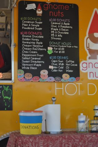 A donations bucket sits below the GnomeNuts menu on the outside of their food cart.