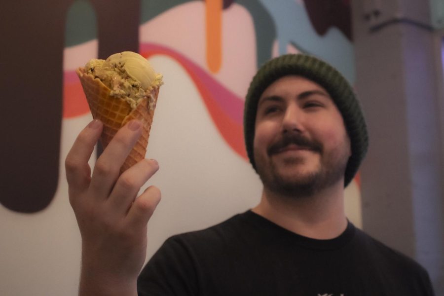 Nathan Burns (he/him), the manager, poses with freshly-scooped ice cream on Jan. 13th at Sugar J’s Ice Cream Workshop in Corvallis, OR. Sugar J’s ice cream formulates all of its recipes in-house, rotating through flavor listings periodically.