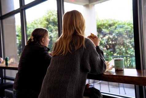 Lucy Goracke (left; she/her) and Eloise Anderson (she/her), enjoying lunch at the North Porch Cafe in Corvallis, Ore. on Jan. 17. The North Porch Cafe has window seating that looks out to the Memorial Union Quad.