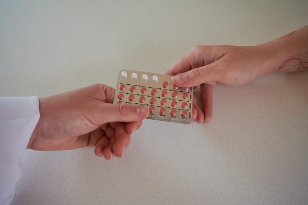 Two hands exchange birth control pill packet on July 25. The birth control pill has now
been approved for over the counter sale.