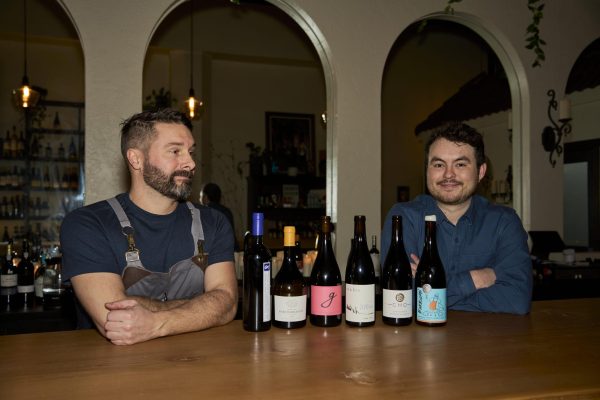  Luke Carlson (left) and Nick Cheatham showcasing some of their favorite wines from the wine wall in Corazon, in Corvallis on Dec. 1. Nick (right), being the owner of Corazon, loves to showcase Mexican wines and wines from many parts of the world, along with local vineyards. 