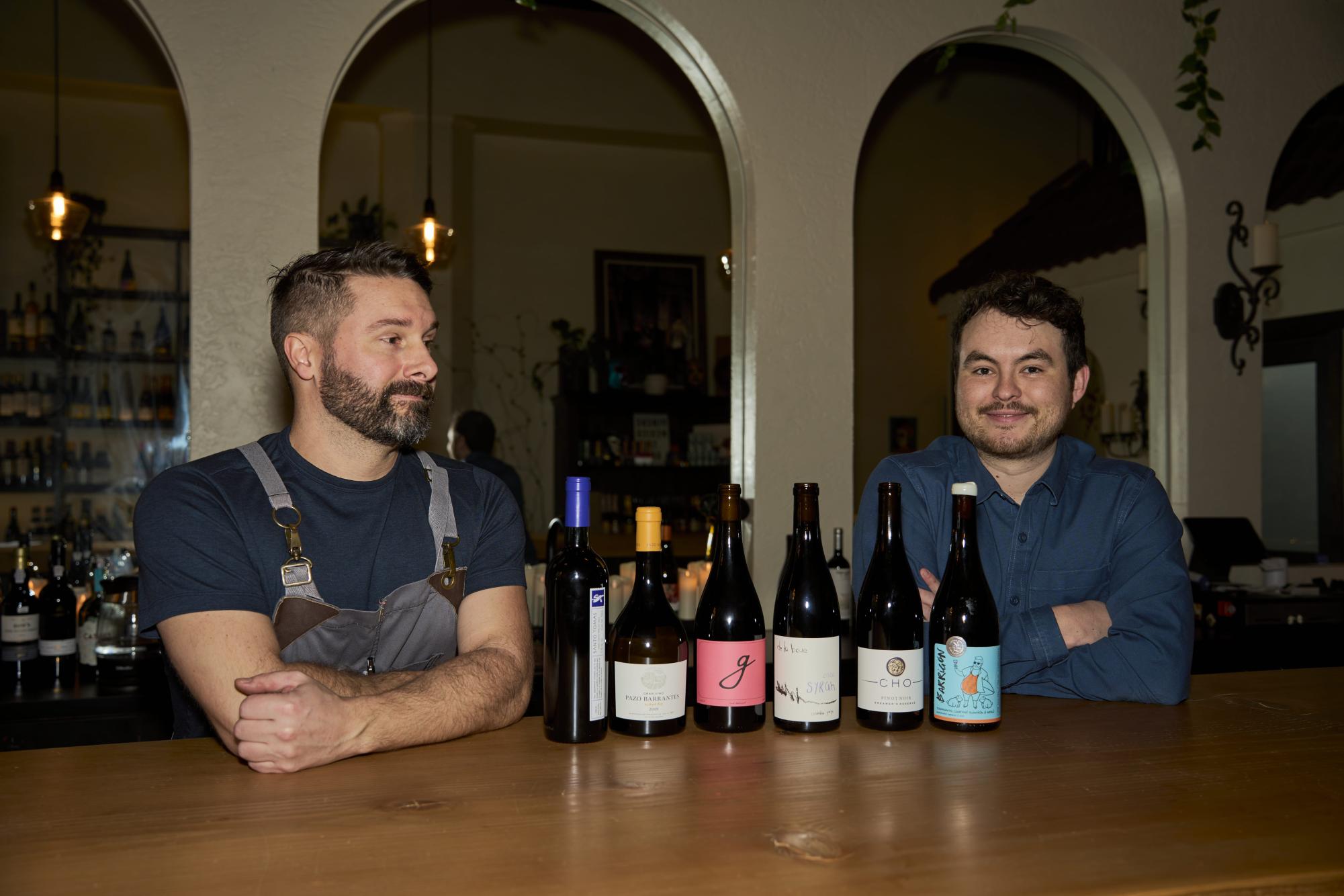  Luke Carlson (left) and Nick Cheatham showcasing some of their favorite wines from the wine wall in Corazon, in Corvallis on Dec. 1. Nick (right), being the owner of Corazon, loves to showcase Mexican wines and wines from many parts of the world, along with local vineyards. 