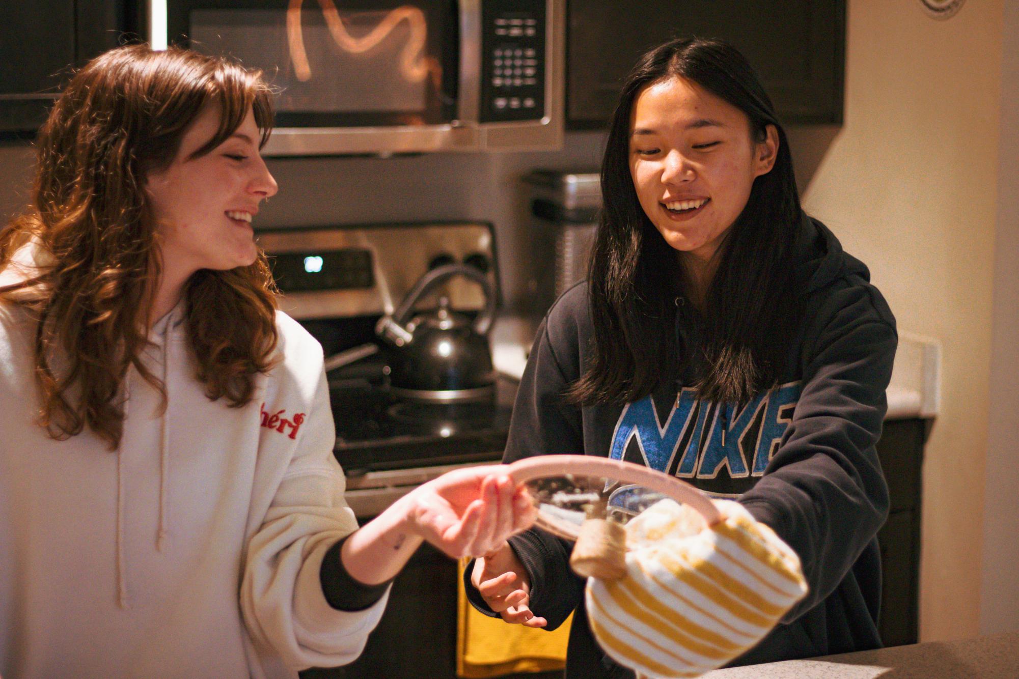 ayton Cowan (she/her) (left) and her partner Jordan Espina (she/they) clean dishes in their home in Corvallis on Jan. 13.
