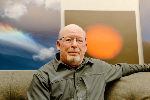 Randall Milstein sits by astronomy-related prints that he photographed in Weniger Hall on Feb. 28, 2024. 