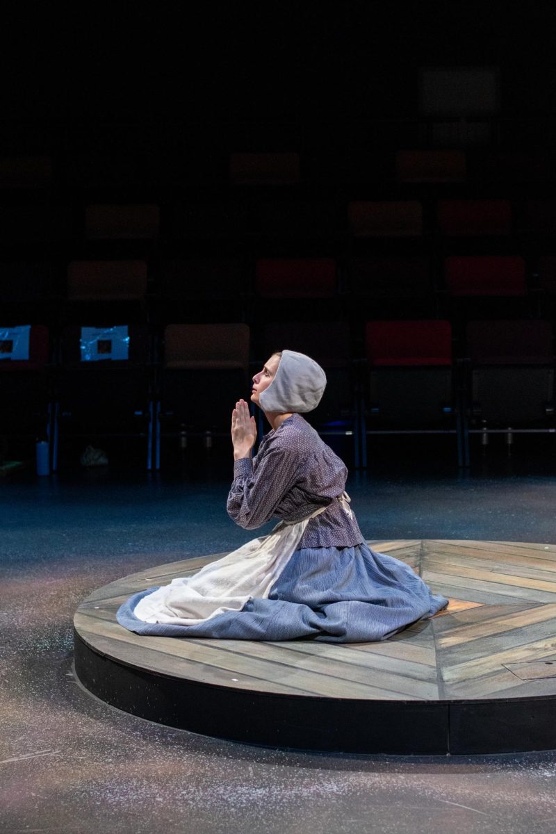 Susan (Sophia Massey) prays during Oregon State University Theatre's production of Vinegar Tom on Nov. 13 in the Edward J. Ray Theater in PRAx. The show explores topics of femininity and bodily autonomy through a story about witches and witch trials.