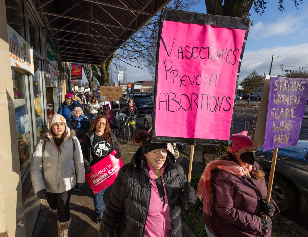 Participants in "The Heart of the Valley Women's March" wave signs as they march through downtown Corvallis, OR, on Jan. 18, 2025.