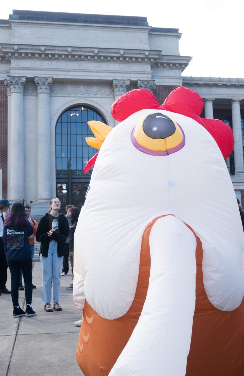 Senior environmental science major, who chose to stay unnamed, poses in blow-up chicken costume in the Memorial Union quad before the No Kings protest begins. The costume signifies that they are not too chicken to protest.
