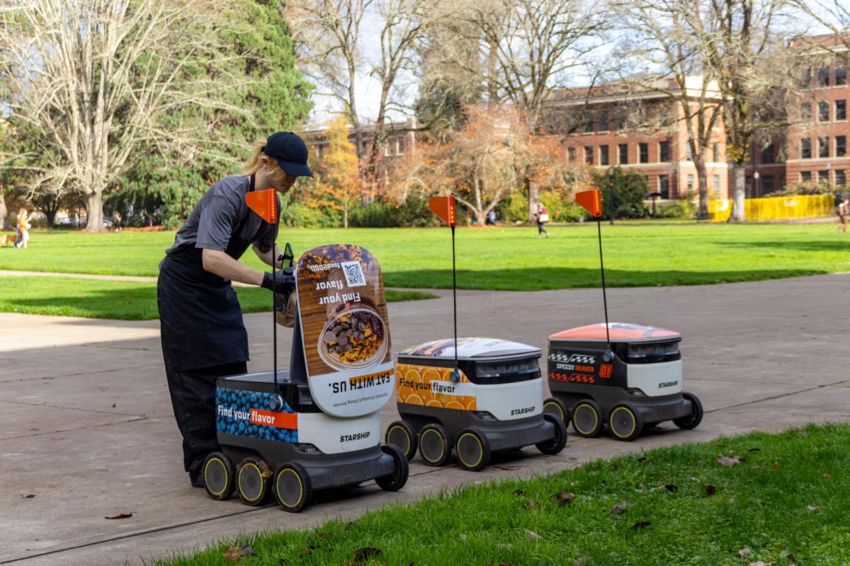 A student employee places a meal inside a delivery robot at the Memorial Union on November 14.This moment shows the growing role of digital tools in providing convenience and efficiency to campus dining.