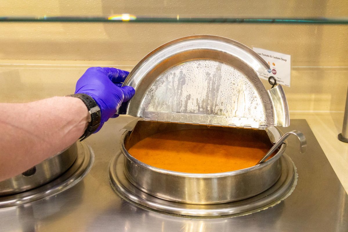 A lid dish of soup is opened by one of the kitchen staff at the West dining Hall on February 16th. This soup flavor is one of a few that are available to students who are going through a period of feeling unwell or have a flu.